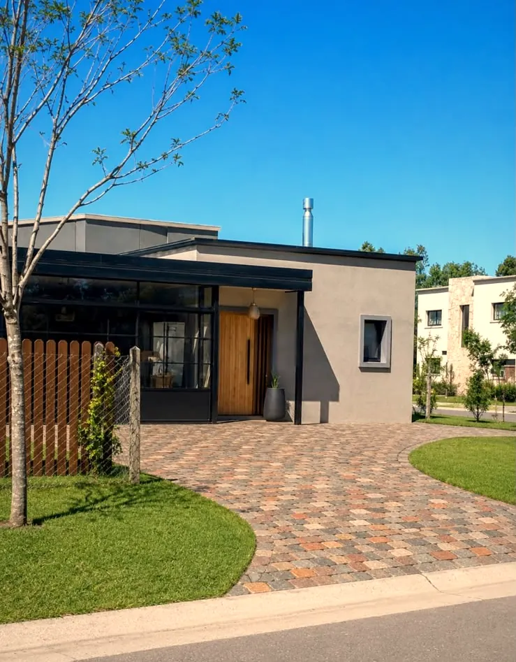 Acceso a casa nueva de 185 m² con alero, muro ciego y carpintería de piso a techo